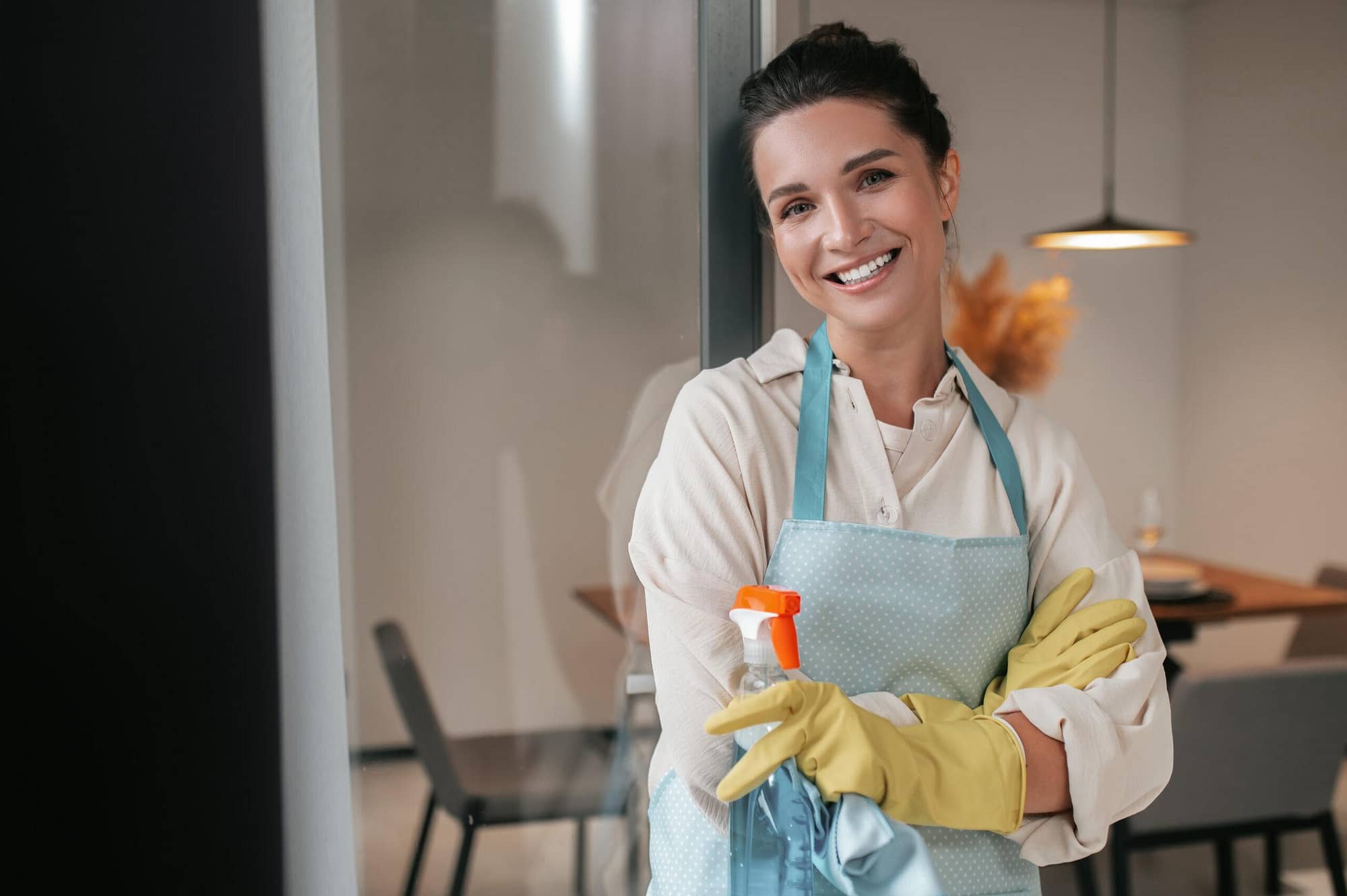 domestic routine smiling housewife in apron standing in the kitchen 1 scaled - Génération de leads pour les services à la personne