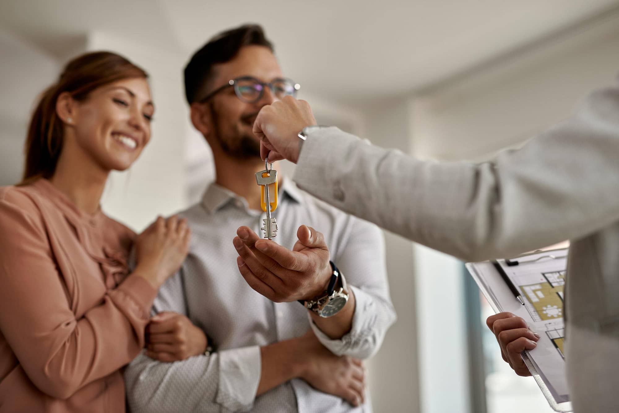 closeup of real estate agent giving to couple keys of their new home scaled - Promoteur immobilier : 1 250€ par vente d’appartements en lignage immobilier